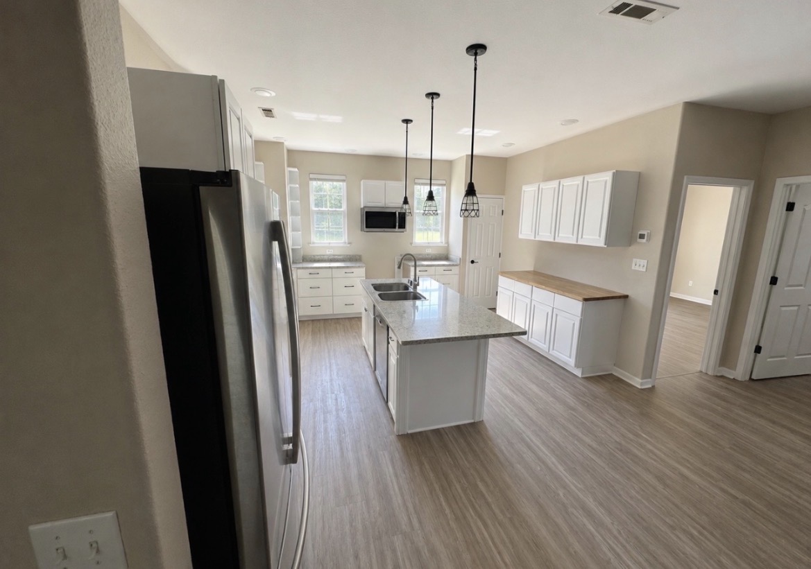 Interior painting in a bright kitchen and living space with clean neutral wall color and crisp white trim