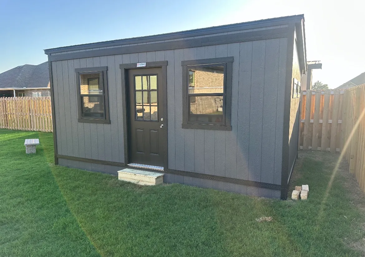 The same shed after customization by Renew Home Solutions, with added skirting enclosing the base, black trim, a finished entry step, and a cleaned-up yard